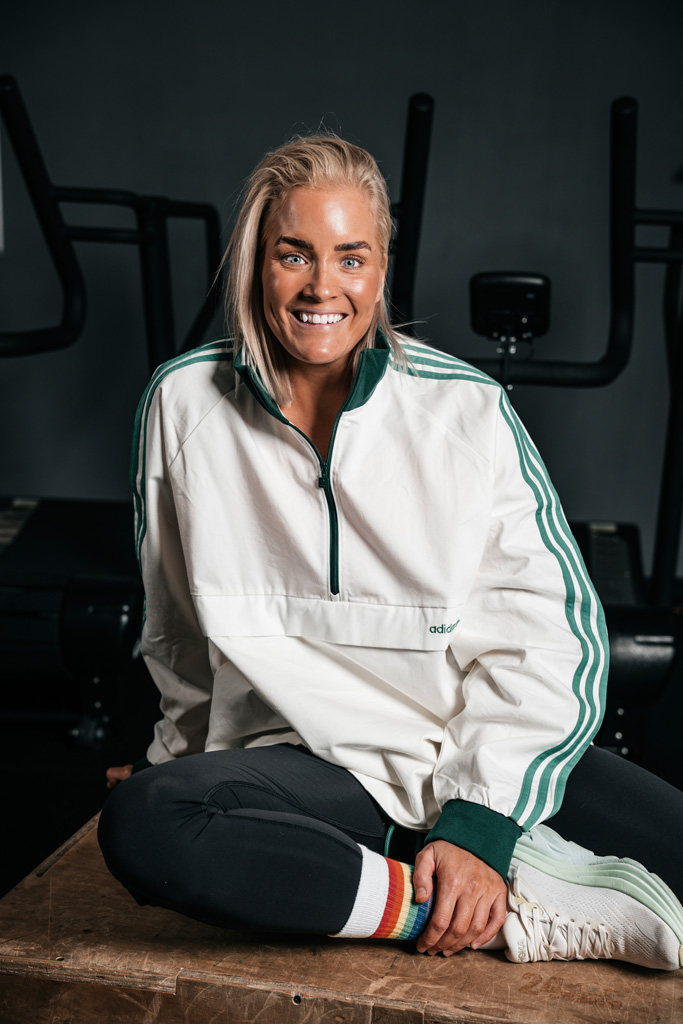 Coach poserar på gymmet med ett stort leende.