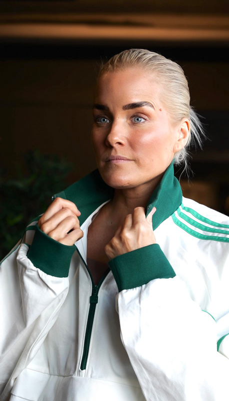 Coach i profil ser allvarlig ut och håller i halsringningen på sin tröja.